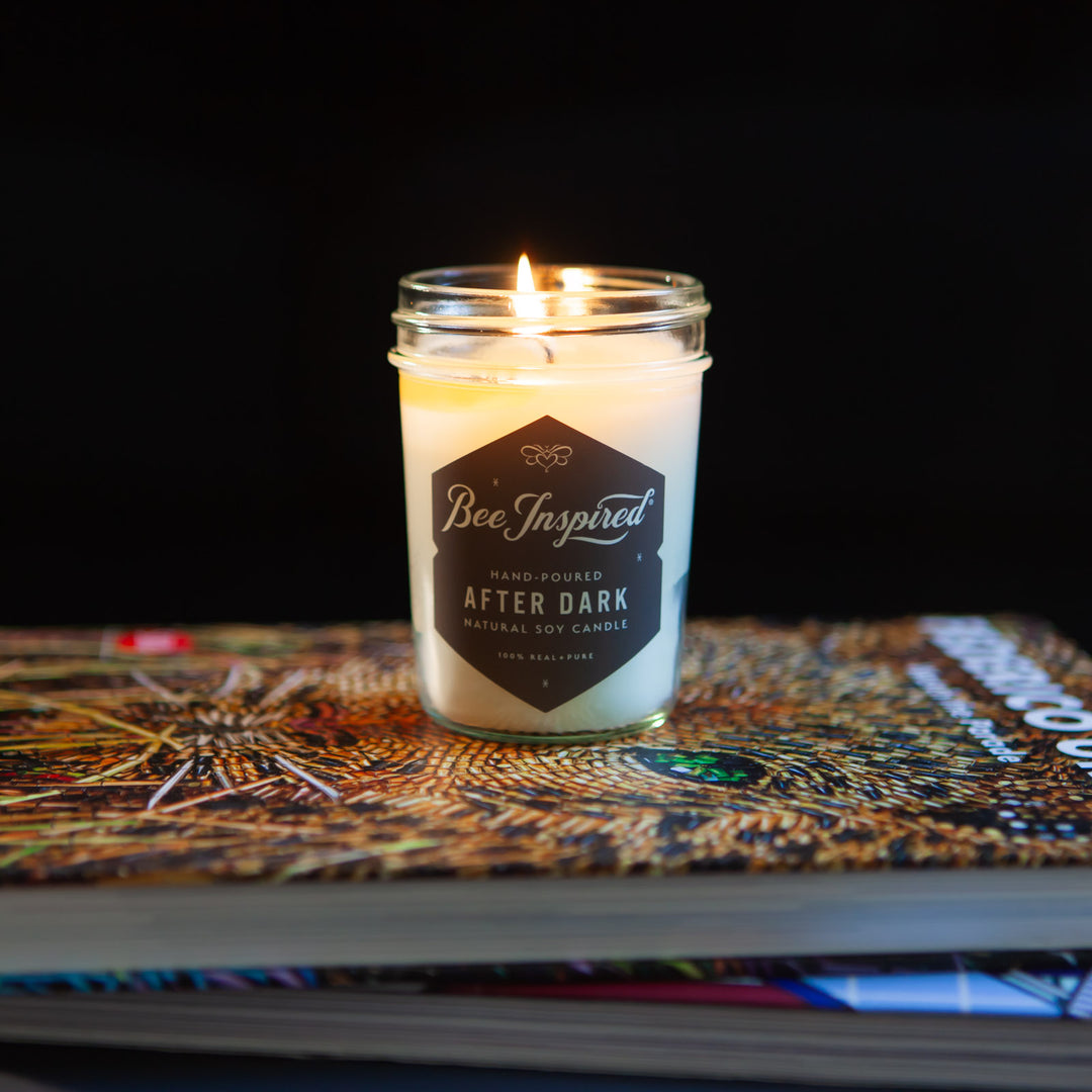 After Dark jelly jar candle burning on stack of books 