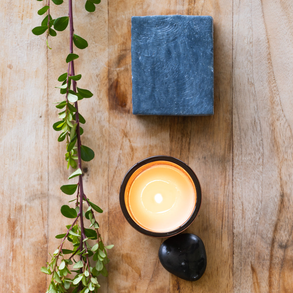 Black clay bar soap with burning candle 