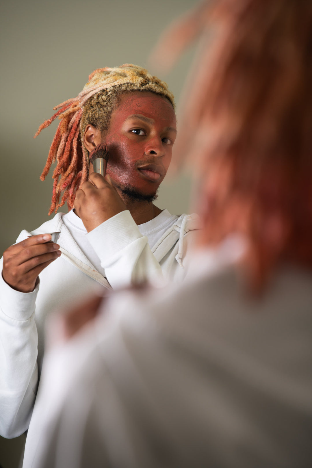 Man applies Clarity mask in the mirror 