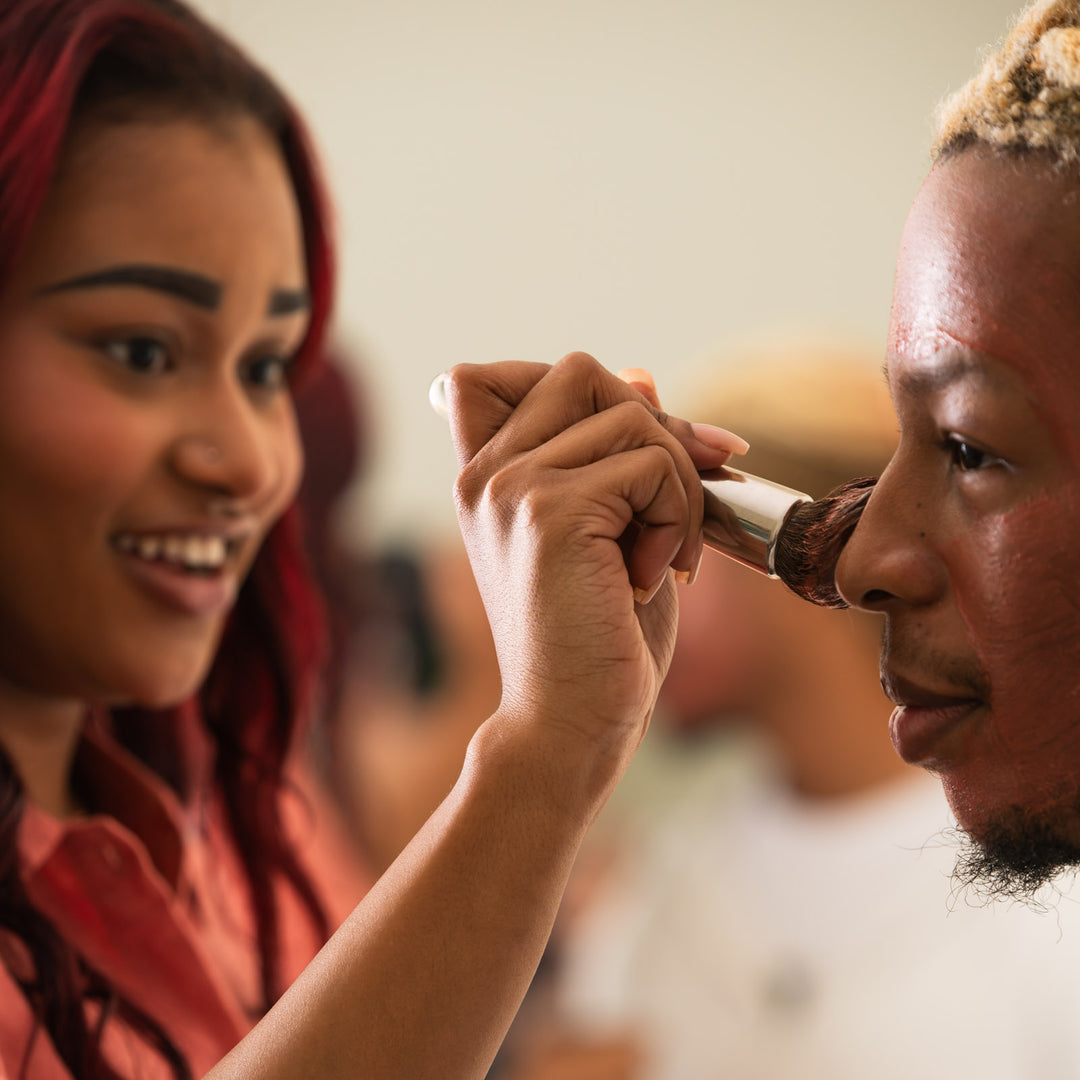 Woman brushes Clarity mask onto a man's chin 