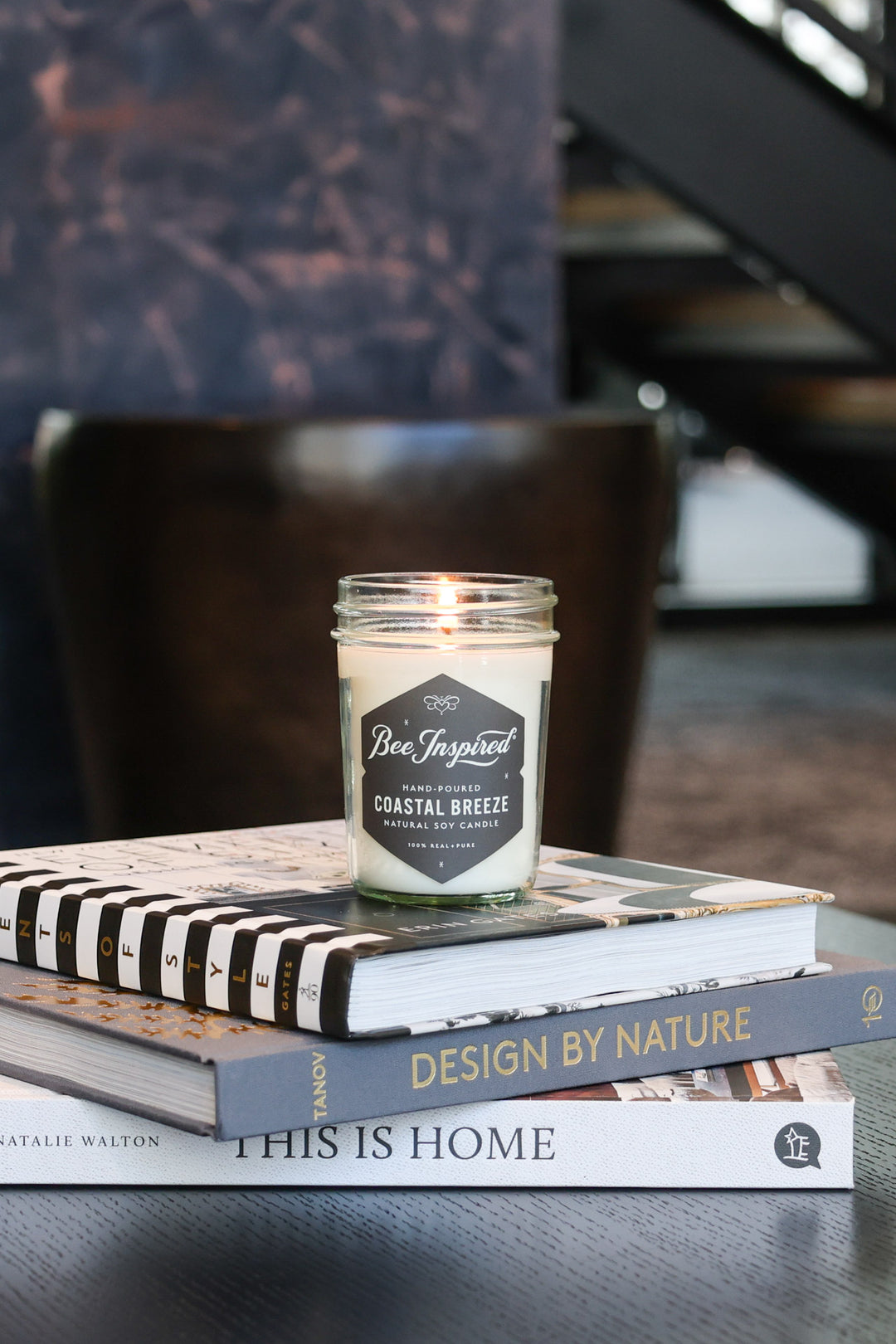 Coastal Breeze jelly jar candle burning on stack of books 