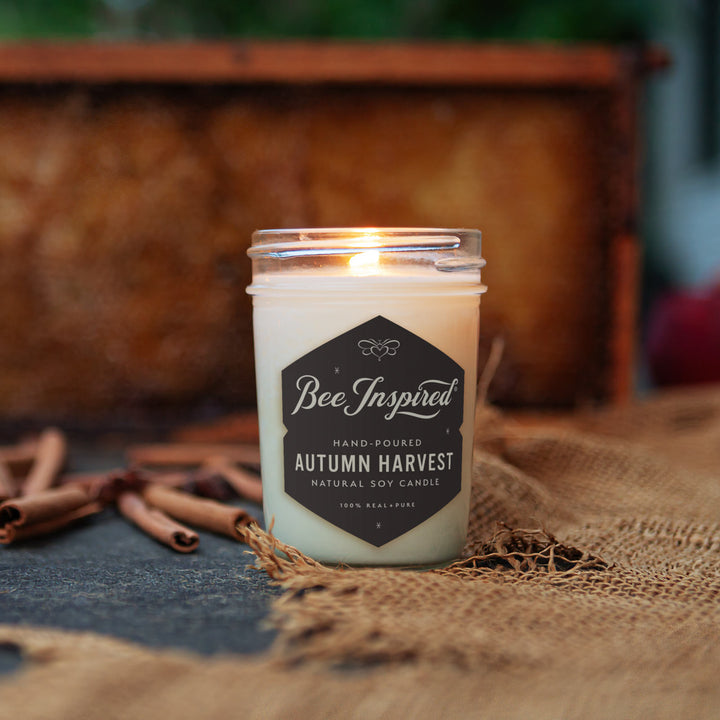 Autumn Harvest jelly jar candle burning next to burlap and cinnamon sticks 