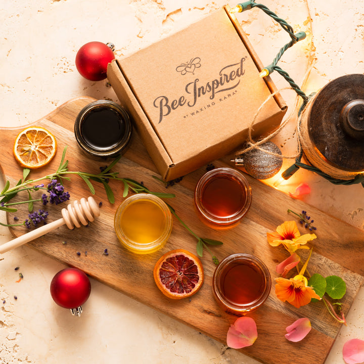 Honey gift set on cutting board with dried fruit and flower petals 