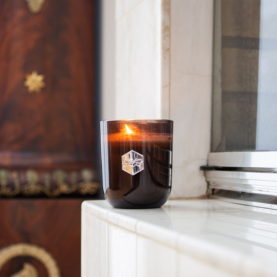 Luxe candle burning in windowsill 