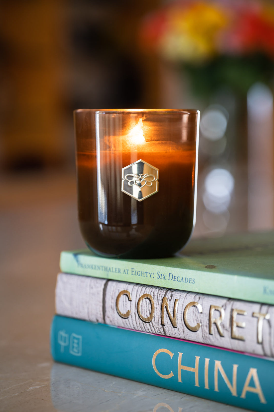 Luxe candle burning on stack of books 