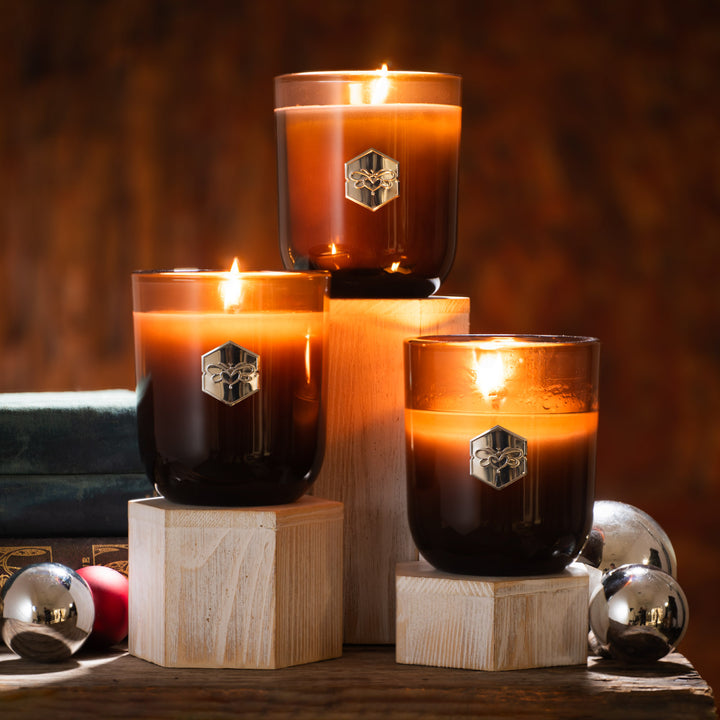 Three luxe candles burning on birch displays 