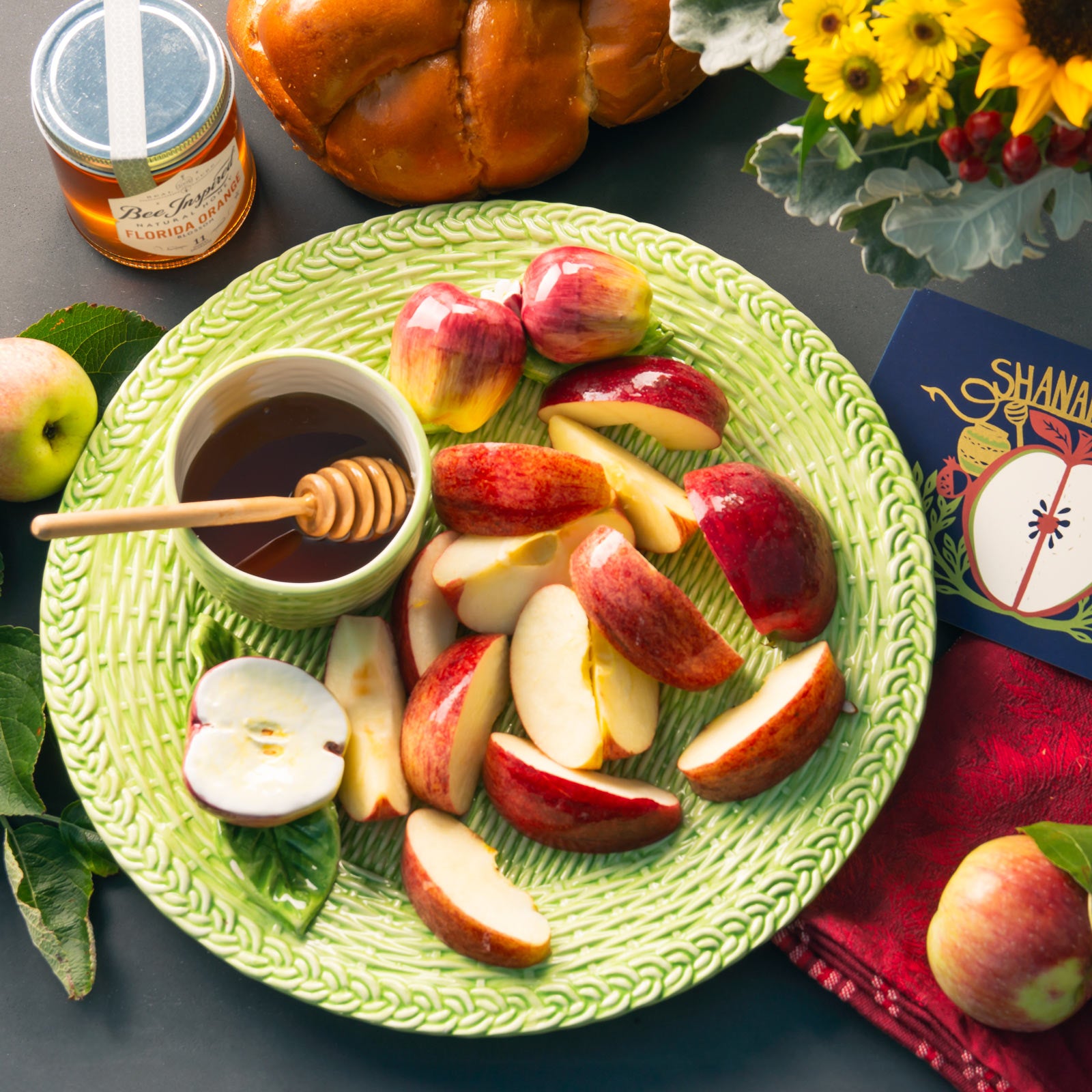 Plate of apple slices with bowl of honey 