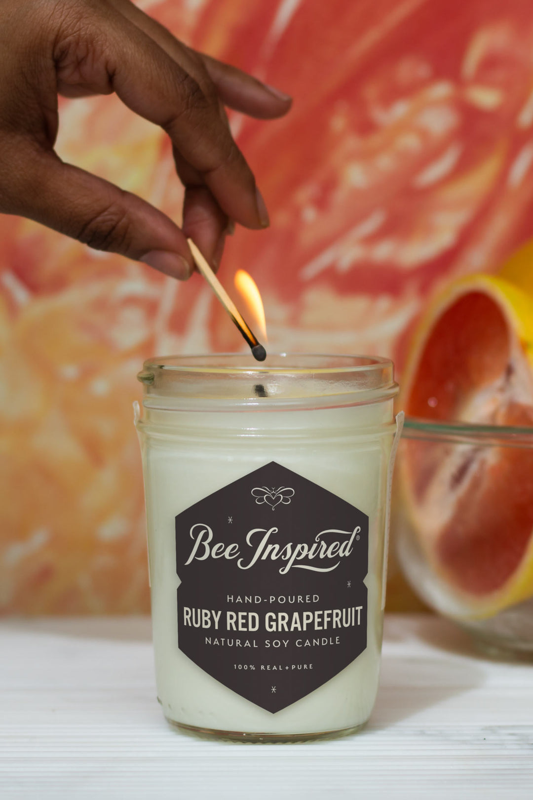 Ruby Red Grapefruit jelly jar candle being lit with match 