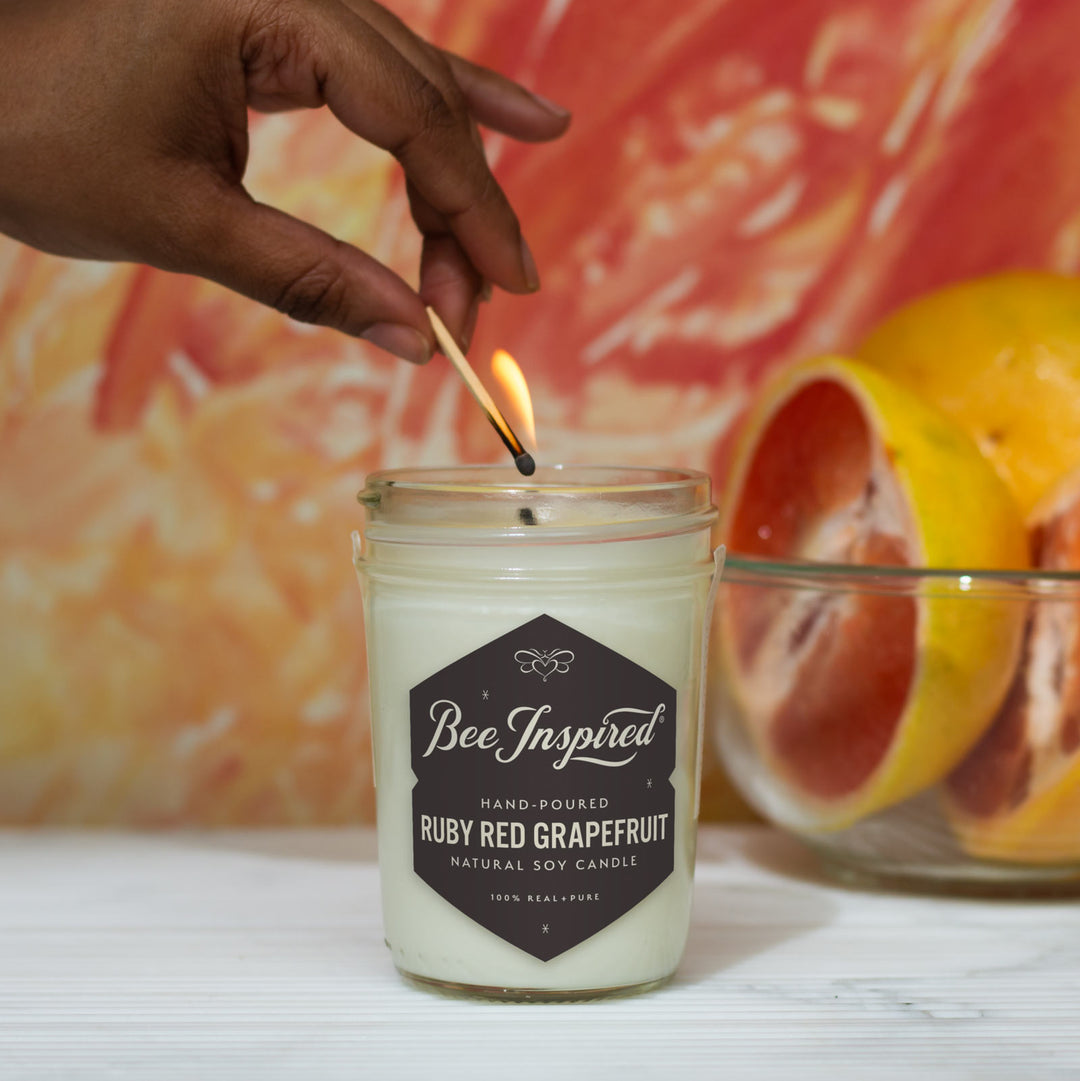 Ruby Red Grapefruit jelly jar candle being lit with match 