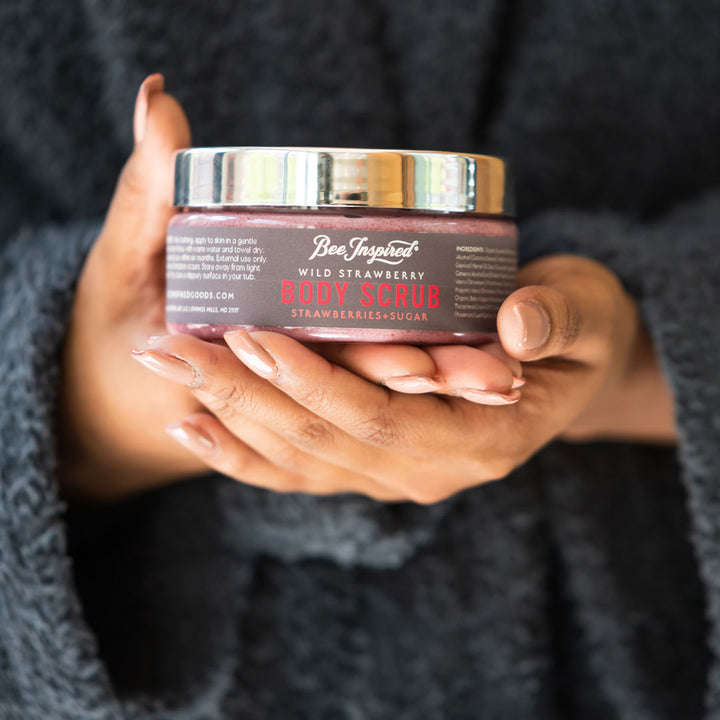 Woman holding Wild Strawberry body scrub 