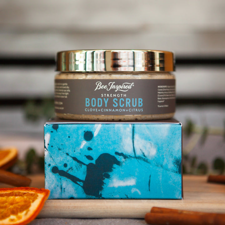 strength body scrub from bee inspired honey retail store in owings mills on its box with orange slices and cinnamon sticks