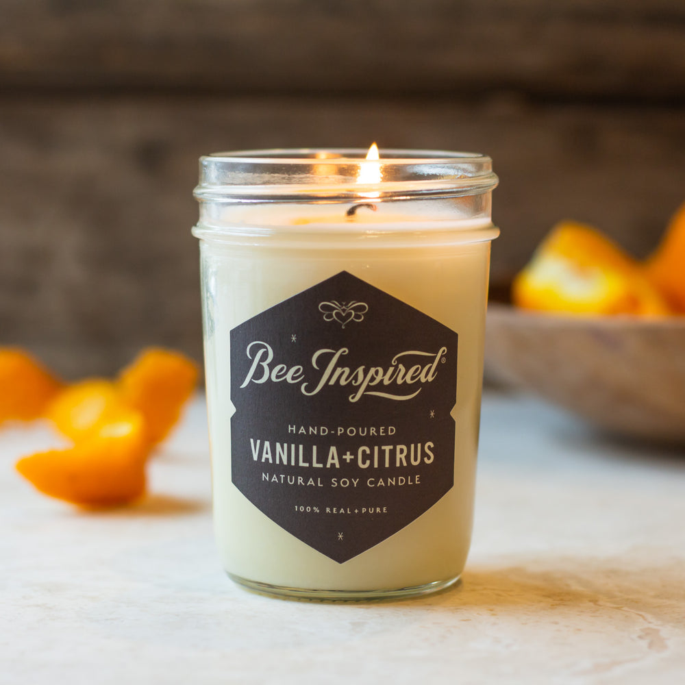 Vanilla Citrus jelly jar candle burning next to orange peel 