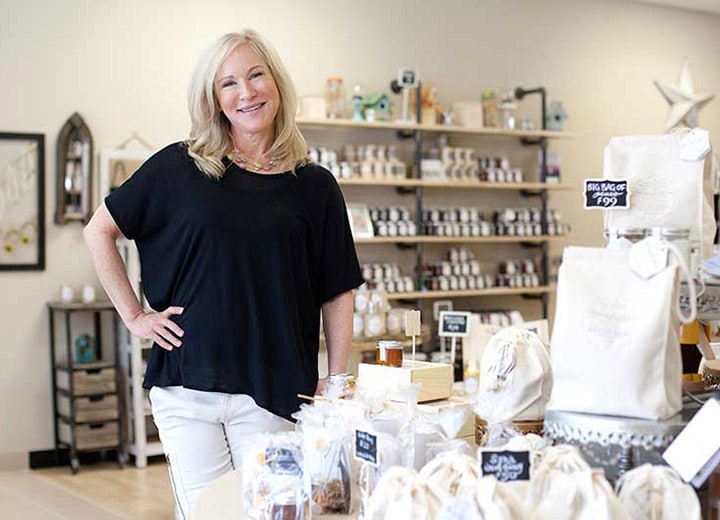 Kara posing next to products in the Honey House 