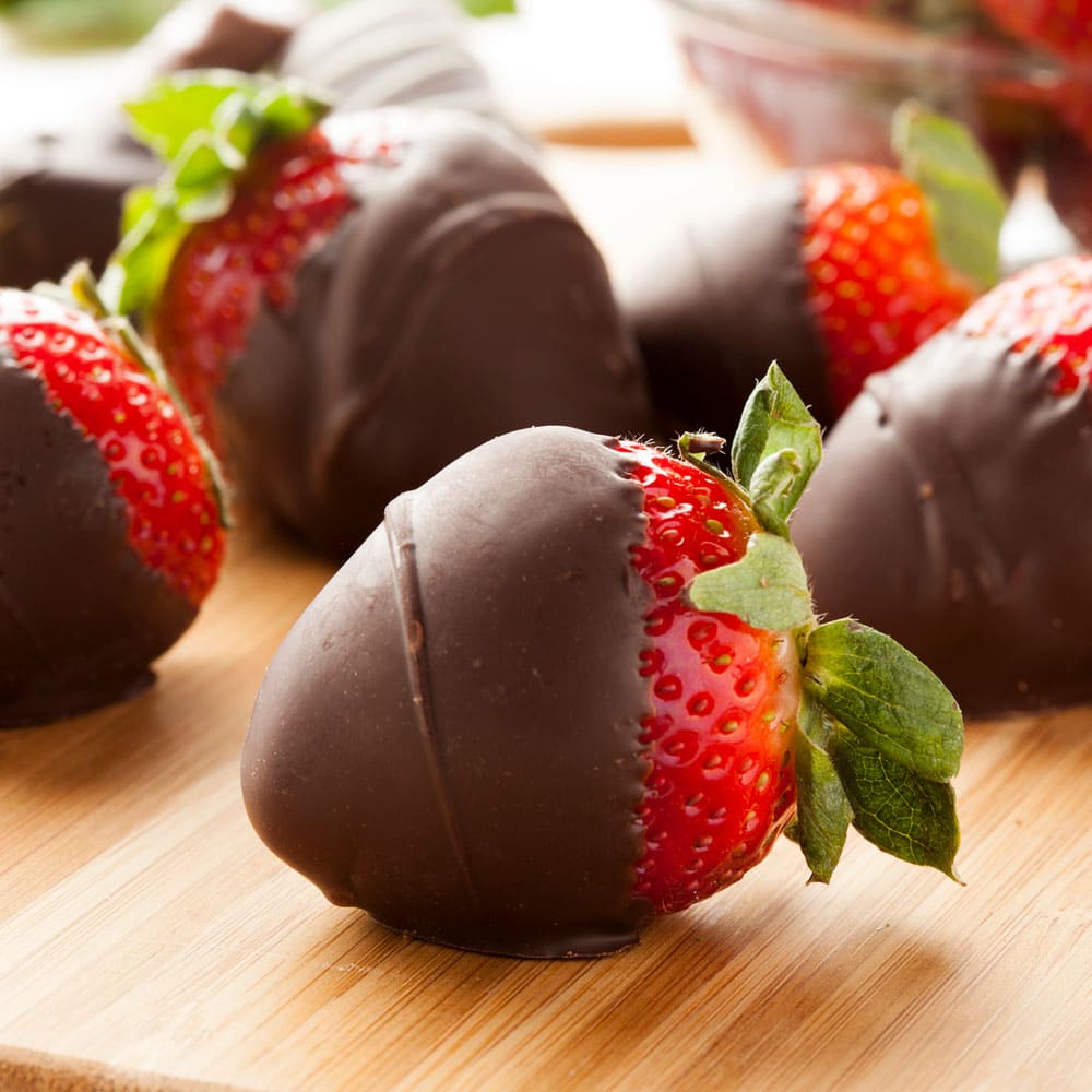 Chocolate covered strawberries on cutting board 