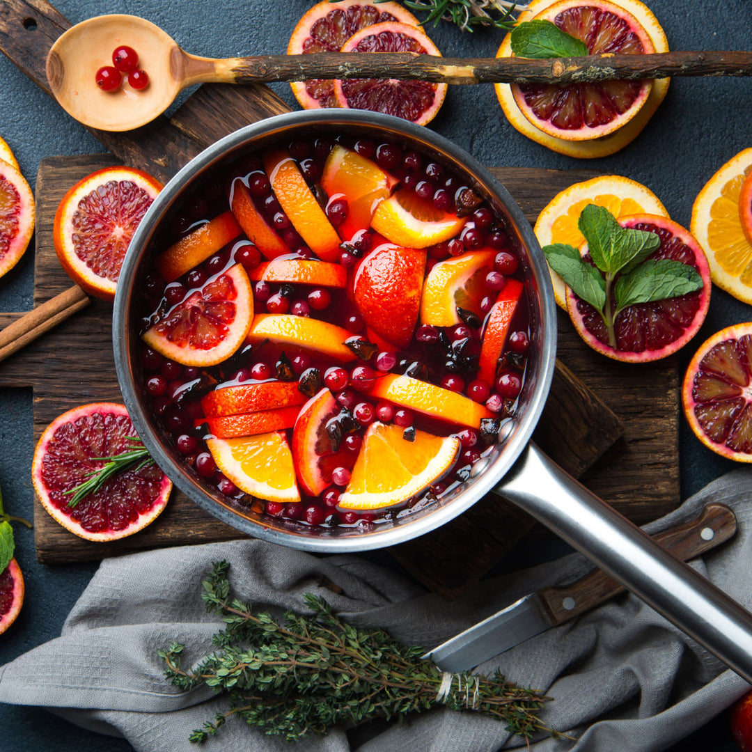 fruits and liquid in a stove pot surrounded by fruit slices