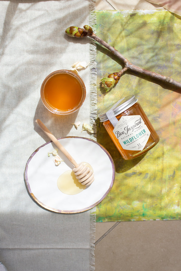 greenspring wildflower honey from bee inspired honey retail store in owings mills with honey dipper on blanket