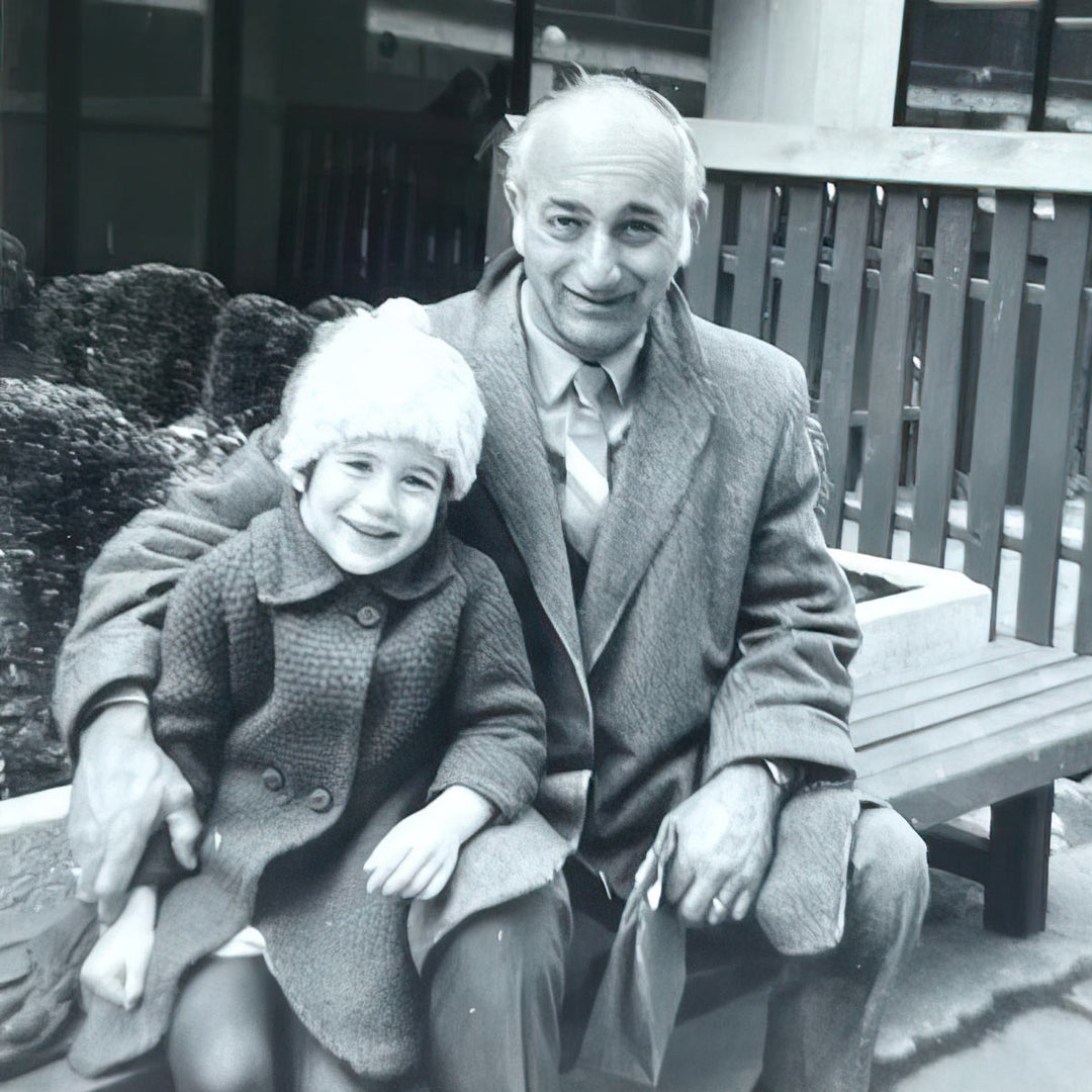 Black and white photo of Kara sitting on a park bench with her dad 