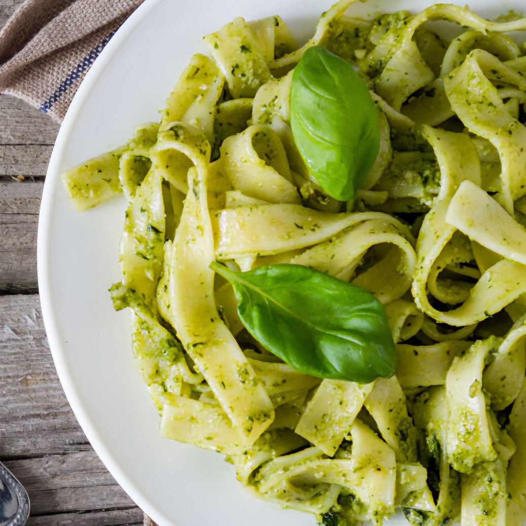 Plate of lemon pesto pasta topped with basil leaves 