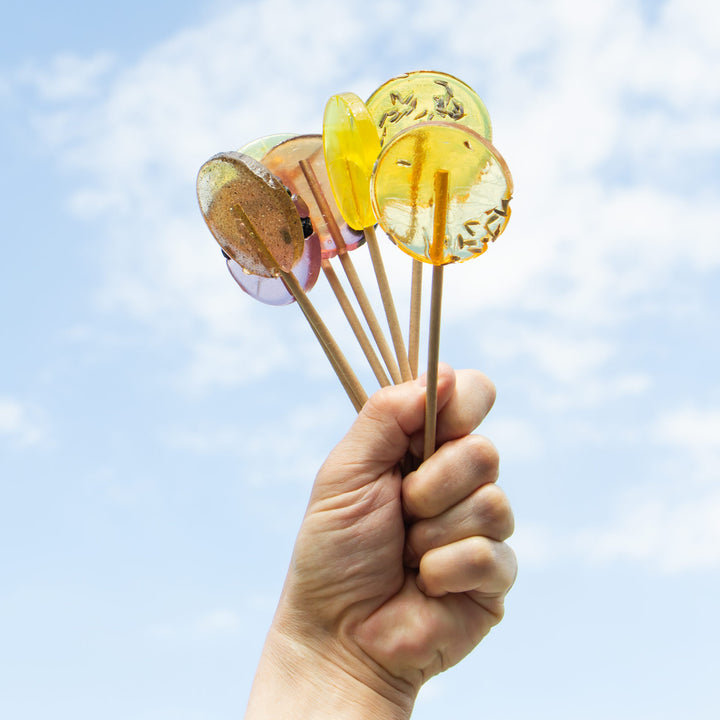 bouquet of a variety of lollipops held to the sky 