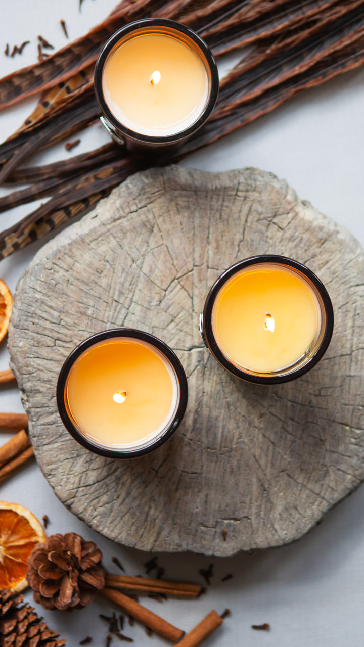 Three luxe candles burning on a log aerial view 