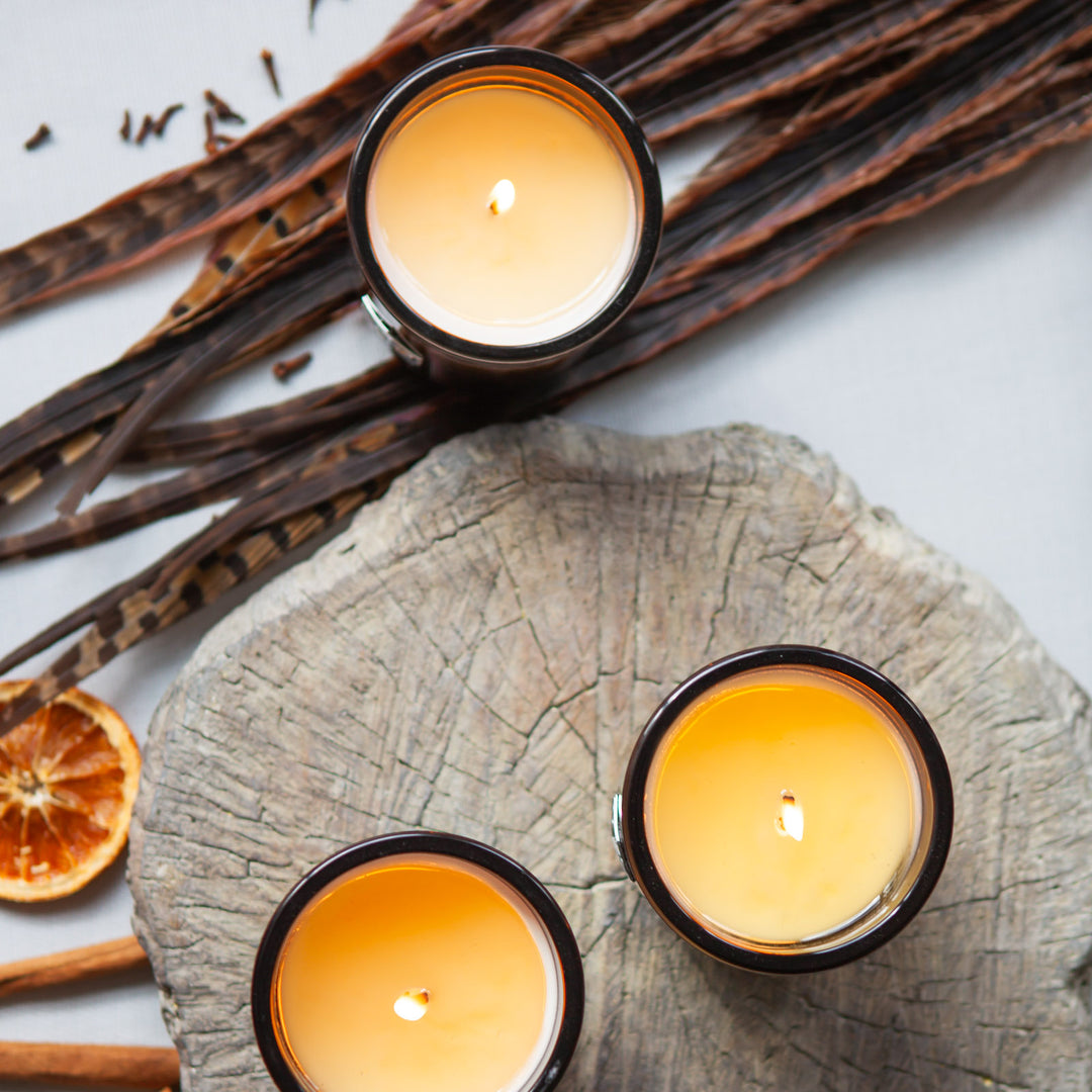 Three luxe candles burning on a log aerial view 