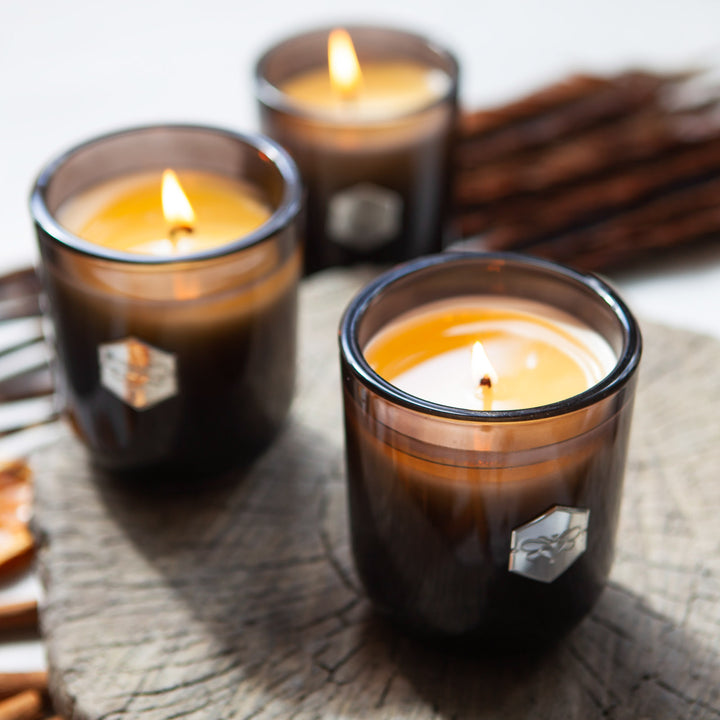 Three luxe candles burning on a log  