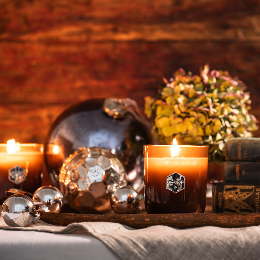 Luxe candles burning next to silver ornaments 