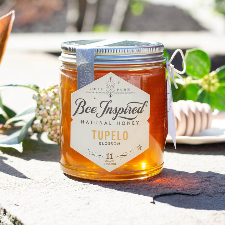 Tupelo honey on stone with honey dipper 